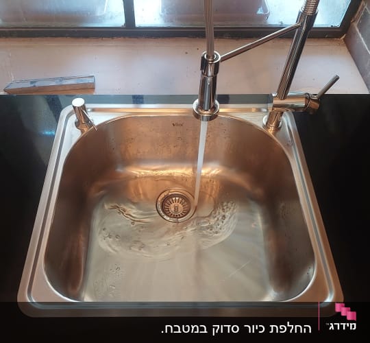 כיור נירוסטה עם ברז מים זורמים